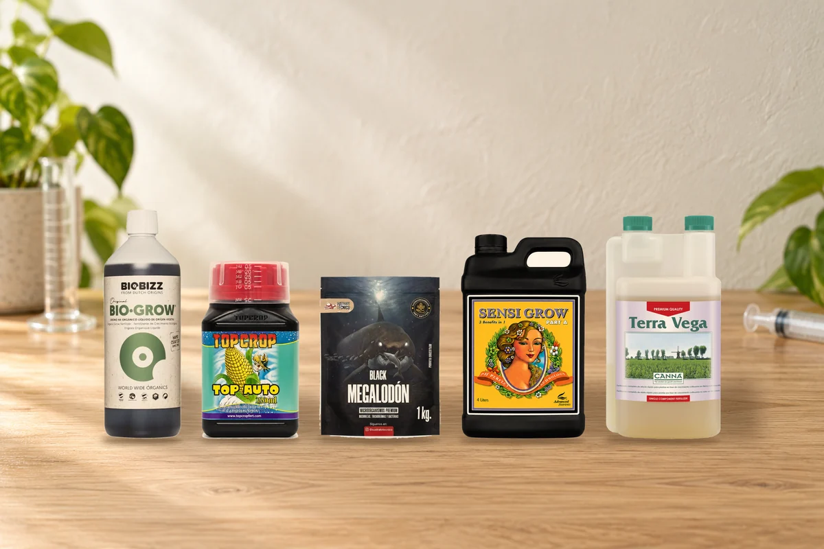 Botellas de fertilizante de distintas marcas ordenadas en dos filas sobre un mesón de cultivo