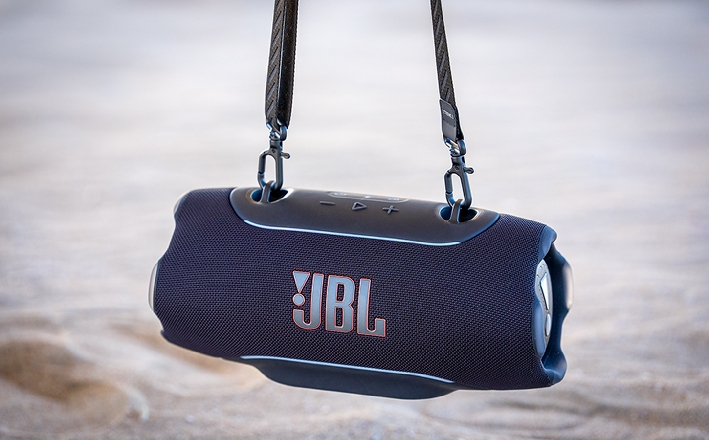 JBL Xtreme 5 negro suspendido con su correa de transporte