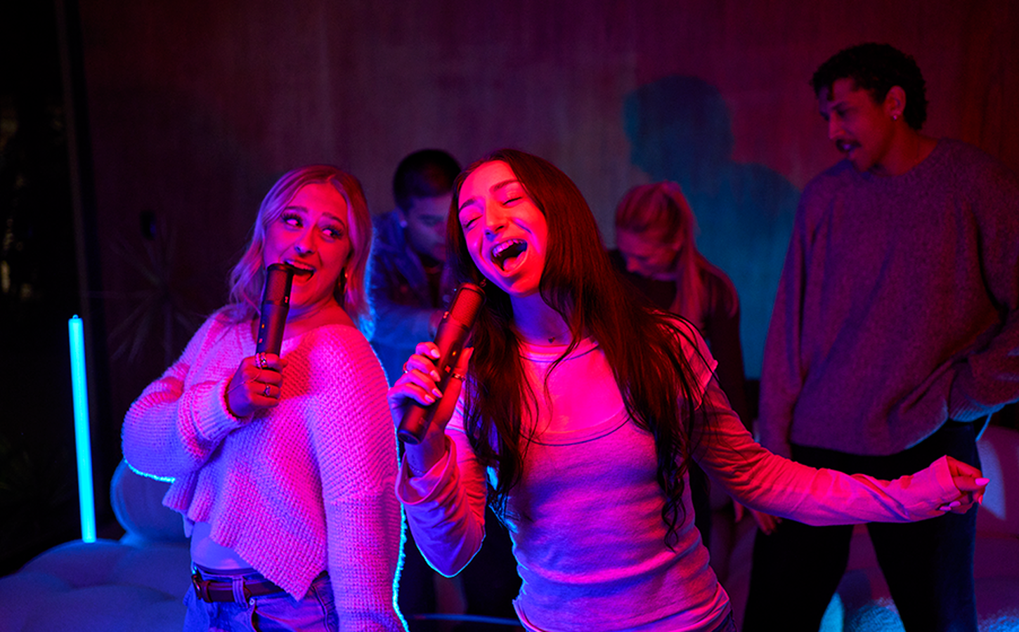 Dos personas cantando con JBL EasySing Mics