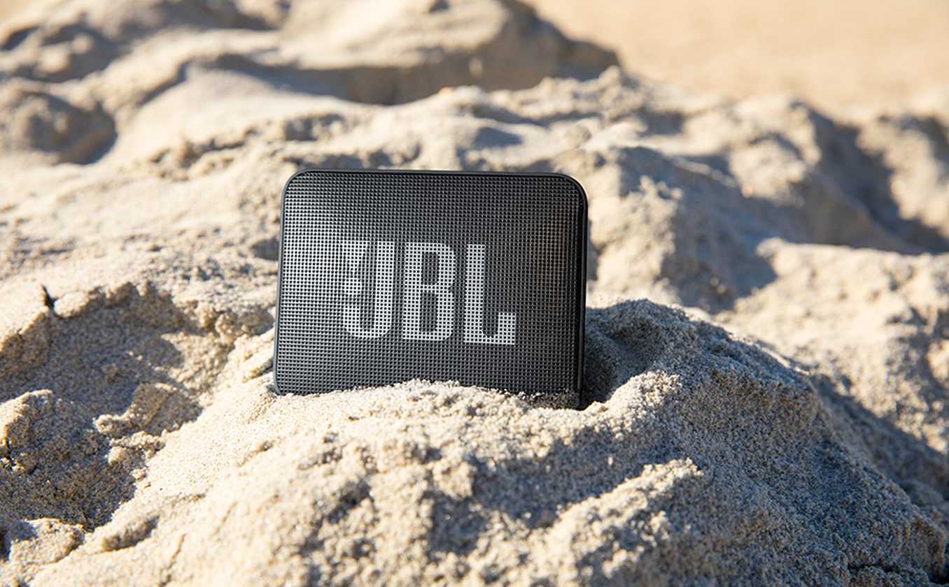 JBL Go Essential 2 en arena demostrando uso exterior