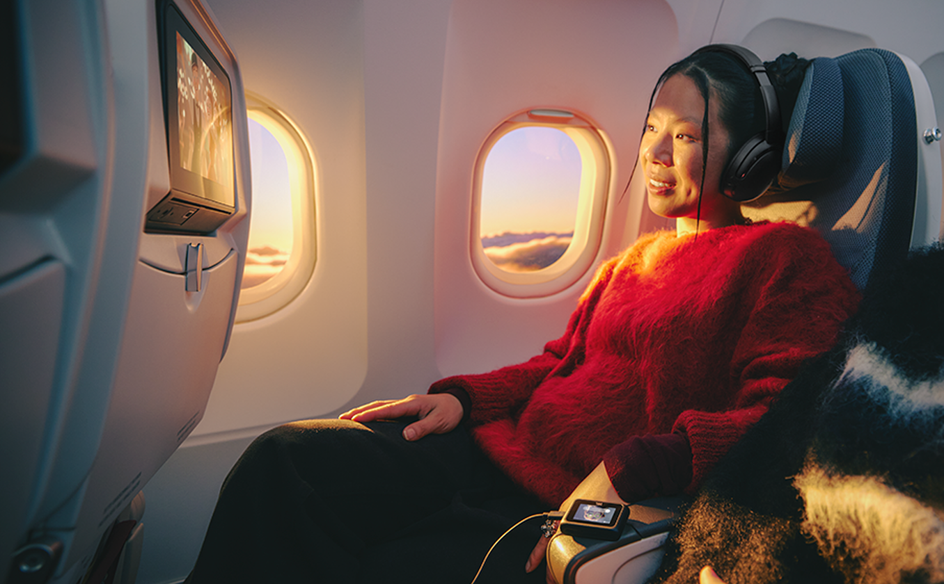 JBL Tour One M3 Smart Tx conectado al sistema de entretenimiento de un avión